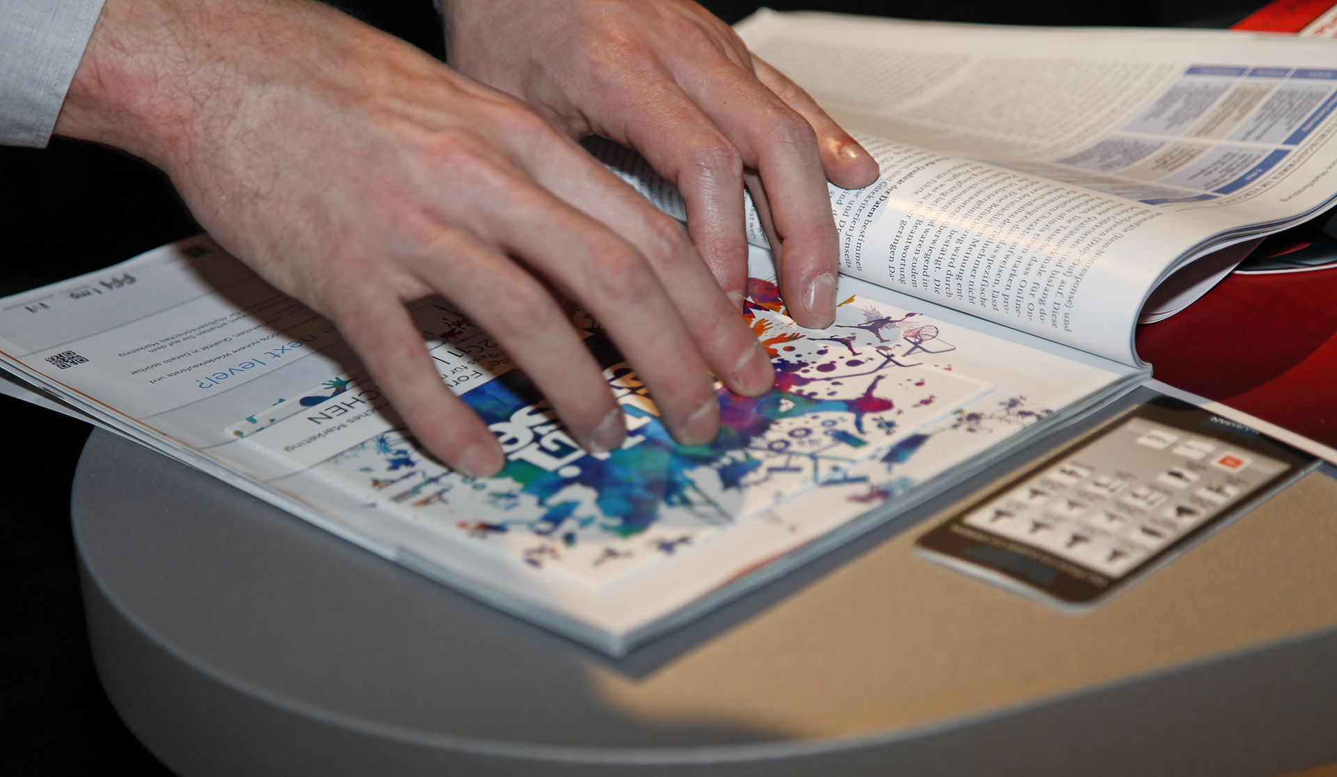 Print oder PDF? Das Mitarbeitermagazin ©multisense Mitarbeiter legt Hand auf Mitarbeiterzeitschrift