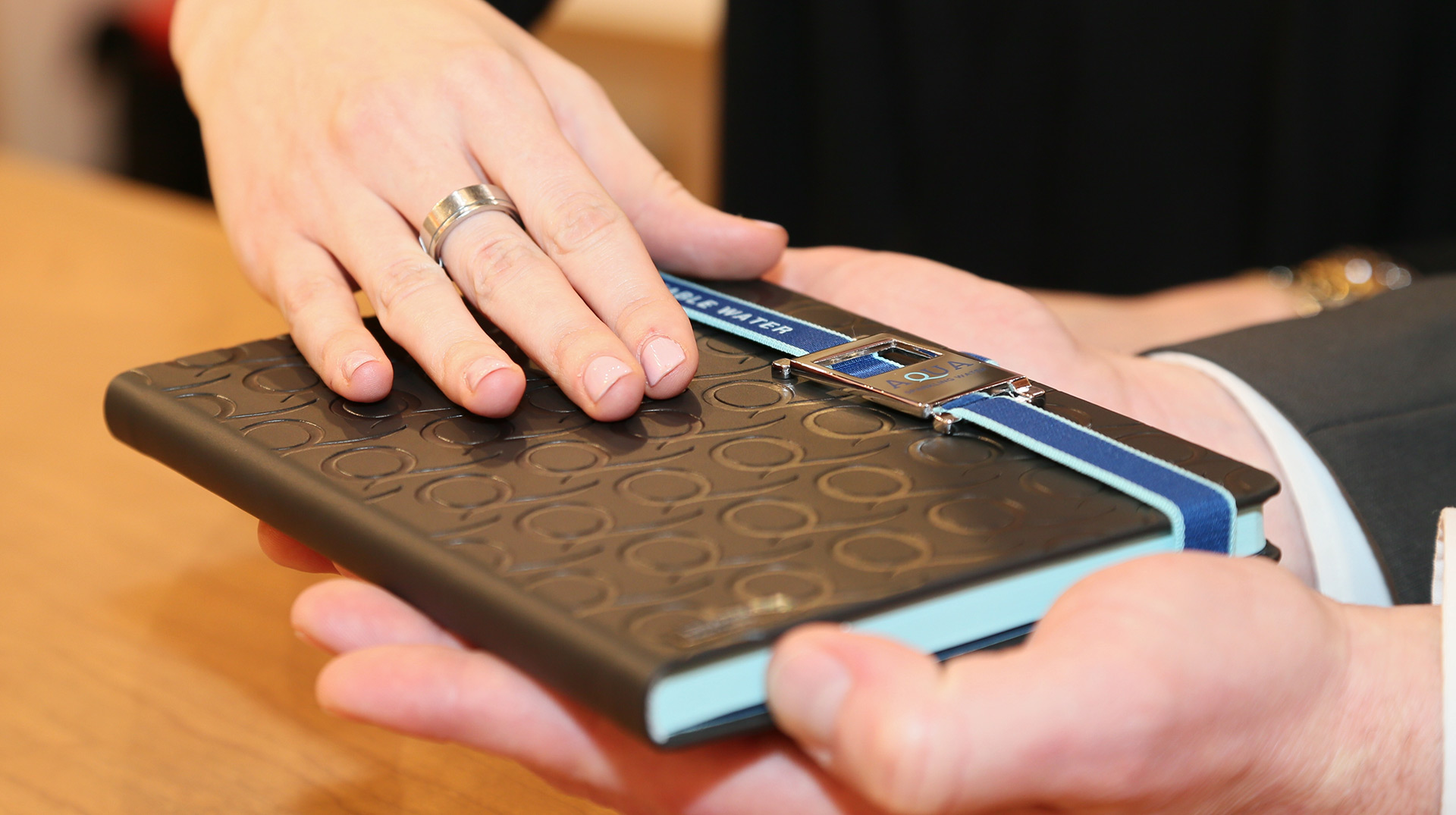 Haptik im Verkauf ©stapag Kunden ertasten ein Notizbuch - Vertrauen aufbauen durch Greifbarkeit