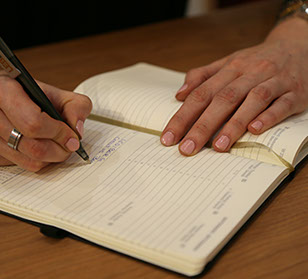 Hand schreibt in Notizbuch