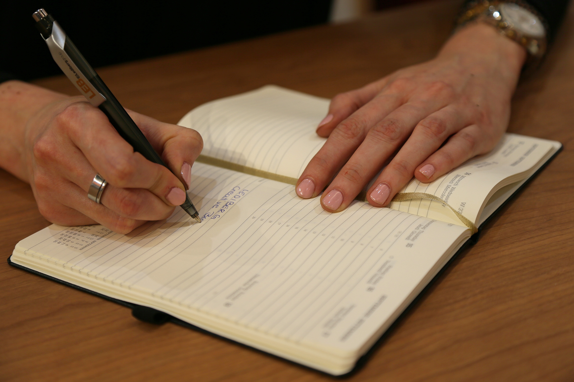 Hand schreibt in Notizbuch