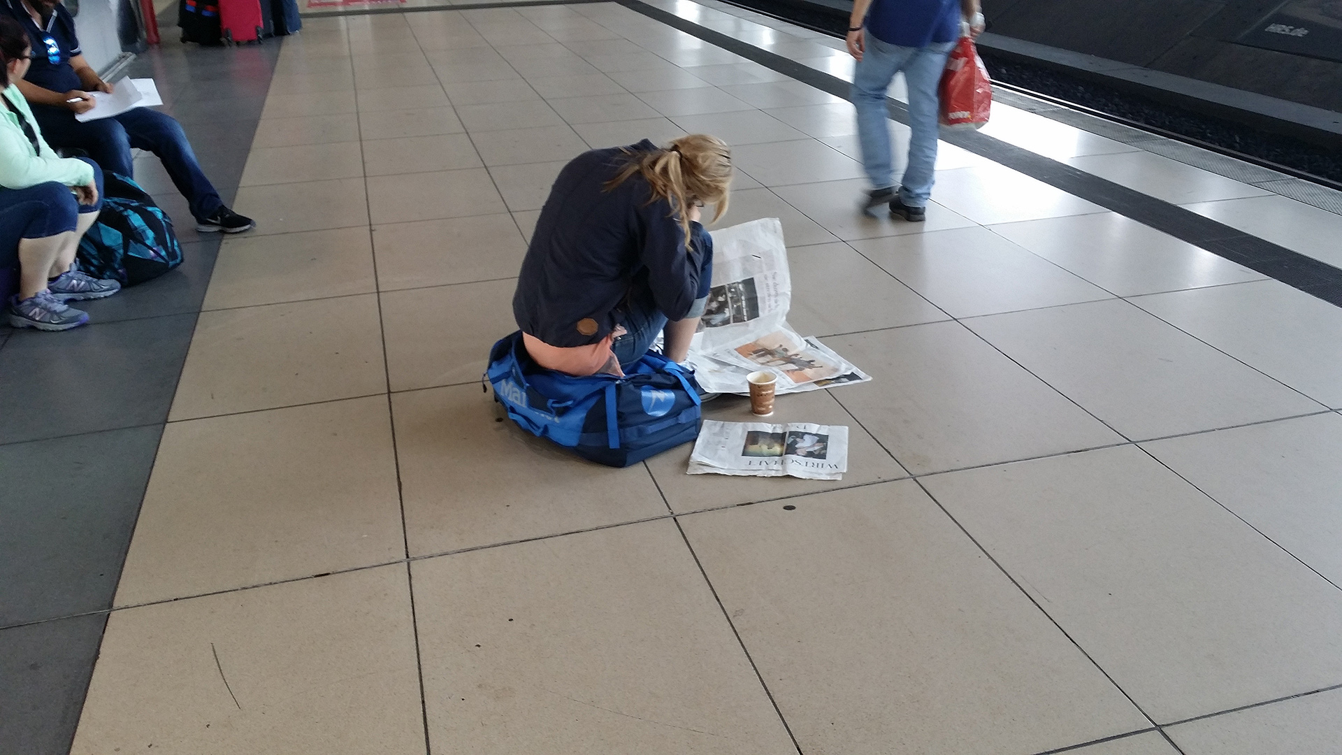 Printmedien sind Fokusmedien ©stapag Zeitungslesende Frau am Bahnsteig - Printprodukte symbolisieren Entschleunigung und Privatsphäre