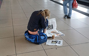 Zeitungslesende Frau am Bahnsteig - Printprodukte symbolisieren Entschleunigung und Privatsphäre